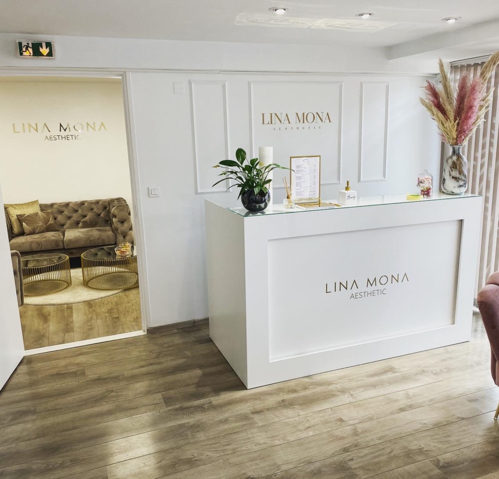 Comptoir d’accueil avec logo doré Lina Mona Aesthetic en lettres découpées installé à Toulouse